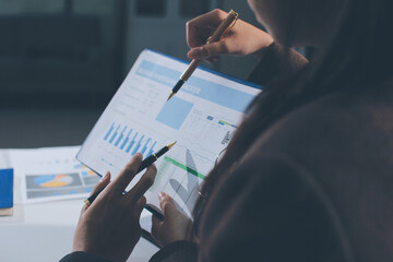 Focused young businessman signing agreement with skilled lawyer in eyeglasses. Concentrated financial advisor showing place for signature on paper contract document to male client at meeting in office