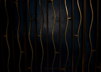 Gold metal fence with rods on a dark blue wall background