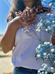 on the beach girl in a white t-shirt and jeans with flowers