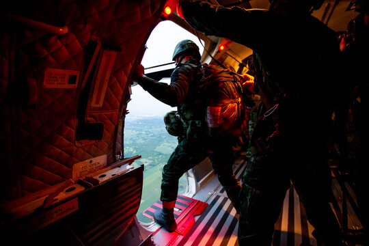Paratroopers Ready for Jump
,Soldiers preparing to jump from a military aircraft, capturing the intensity and focus before a parachute training mission.
