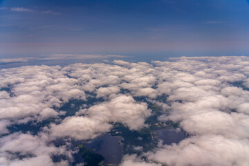 Aerial view of clouds, land, and water.