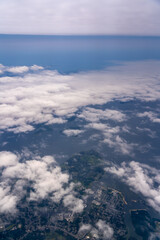 Aerial view of land, water, and clouds.