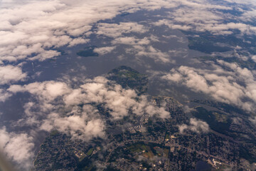 Aerial view of land, water, and clouds.