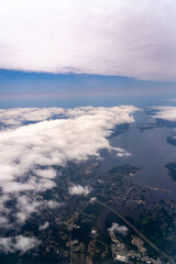 Aerial view of land, water, and clouds.