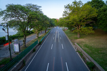 Road lined with trees and blurred car lights.