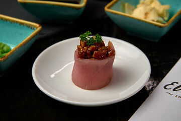 A Deliciously Crafted Sushi Delight Featuring Fresh Tuna Wrapped with Gourmet Ingredients and Garnished with Herbs for an Exquisite Culinary Experience