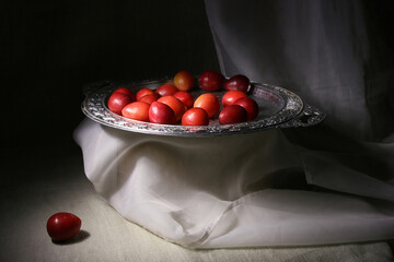 Red plum on a silver tray