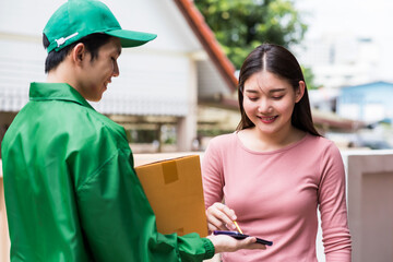 Smiling Asian woman sign to pick up parcel box from delivery man