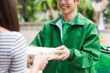 Smiling deliveryman give pizza in paper box to female customer