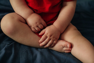 Little cute baby feet and hands on blue sheet, concept of cozy and happy childhood, kid's lifestyle