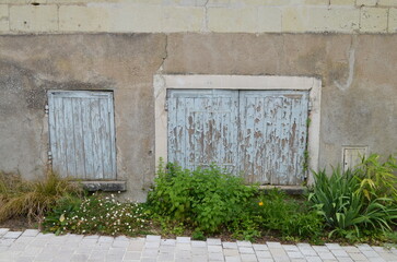 Vieil façade avec un trottoir végétalisé.