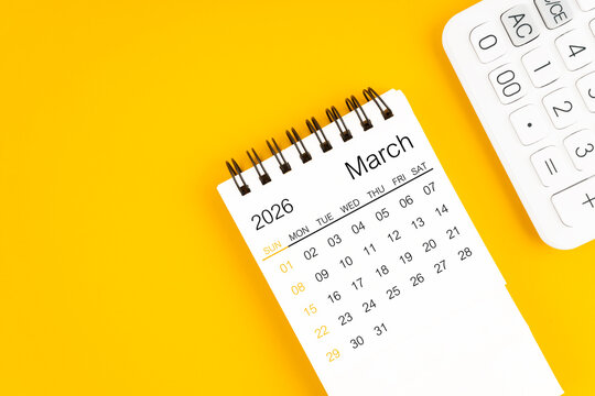 March 2026 calendar and calculator on yellow background, Flat lay.