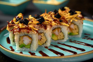 A Delicious Arrangement of Sushi Rolls Artfully Presented on a Vibrant Blue Plate, Highlighting...