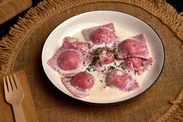 Delicious Plate of Vibrantly Colored Ravioli Served in Creamy Sauce with Herbs, Perfect for a Gourmet Dining Experience at Home