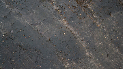 Top view of dark black and brown stone slabs. Different patterns create beauty. Wet surface. For background and textured.
