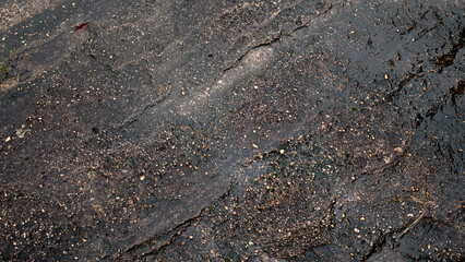 Top view of dark black and brown stone slabs. Different patterns create beauty. Wet surface. For background and textured.