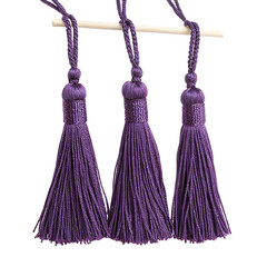 Elegant purple tassels hanging from a rod showcasing exquisite artisanal craftsmanship and style