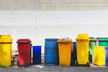 Lot of colorful trash cans on street. Wheelie bins in row segregated for recycling rubbish....