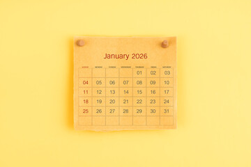 January 2026 brown calendar with wooden thumbtack on yellow color background.