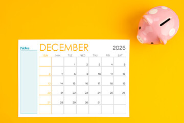 December 2026 calendar and pink piggy bank. Money savings challenge concepts.
