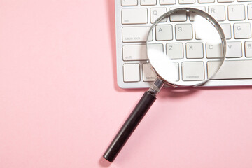 magnifying glass on a white background, computer keyboard