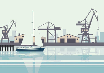 A modern sailboat is moored in the water of an industrial harbor with cargo cranes and warehouses.