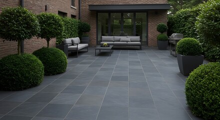 Fototapeta premium Sleek Modern Patio with Graphite Tiles, Sculpted Dark Green Topiary, Minimalist Outdoor Furniture, and Contemporary Garden Design for Stylish Home Entertaining Spaces