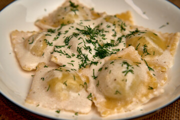 Delicious Plate of Homemade Ravioli Topped with Creamy Sauce and Fresh Herbs: A Culinary Delight for Pasta Lovers