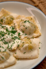 Delicious Homemade Ravioli with Creamy Sauce and Fresh Herbs Served in a White Bowl for a Perfect Culinary Experience