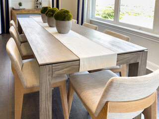 Side view of dining setup with light wood chairs
