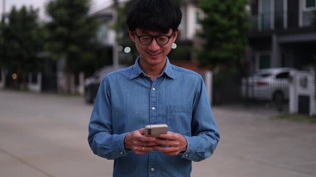 close up young asian man hand hold mobile cell phone device to play social media or read news website on smartphone for relaxing and leisure lifestyle concept