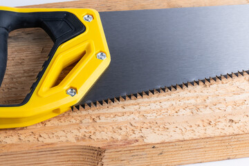 Hand saw on wood board, carpentry and woodwork concept.