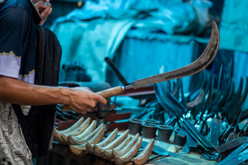 A man holds a sharp iron weapon in the market