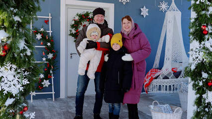 Joyful family gathers on their festive christmas decorated front porch. New Year's Eve with the family. Christmas Day with the family