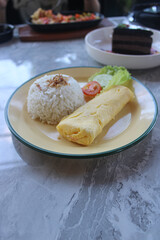 Indonesian Breakfast Set with Omelette, Steamed Rice, and Fresh Vegetables