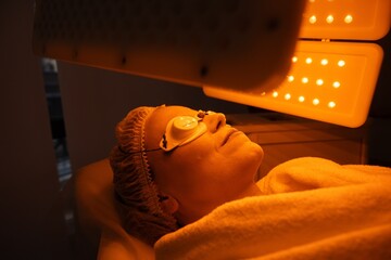 Woman undergoing light therapy treatment at a spa in a tranquil setting