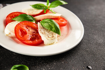 Caprese salad mozzarella and tomato, basil fresh delicious gourmet food background on the table rustic food top view copy space keto and paleo diet vegan and vegan food
