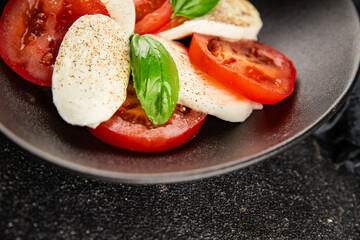 Caprese salad mozzarella and tomato, basil fresh delicious gourmet food background on the table rustic food top view copy space keto and paleo diet vegan and vegan food