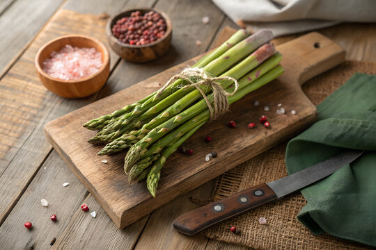banches of fresh green asparagus on wooden background