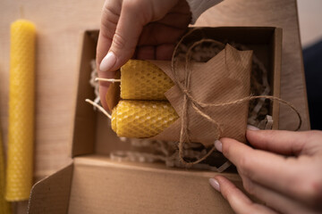 Woman making wax candles and packing it in gift box. Small business and handmade hobbies