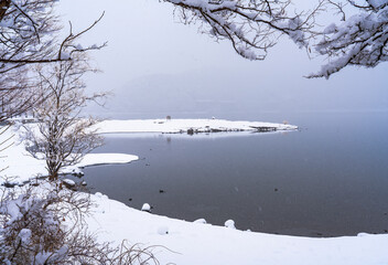 Serene Snowy Lake Kawaguchiko Scene in March with Steel Gray Water
