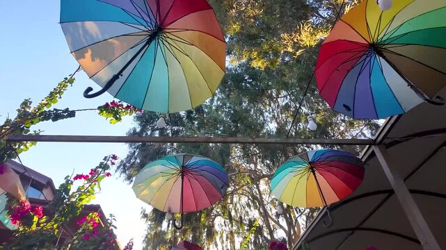 Colorful rainbow umbrellas hanging overhead on famous street in Akyaka town, Mugla, Turkey. Akyaka is a very popular touristic destination in Mediterranean Turkey