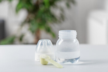 Infant formula scoop and baby bottle preparation. Baby care.