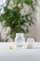 Baby bottle, scoop and formula powder on table. Baby care.