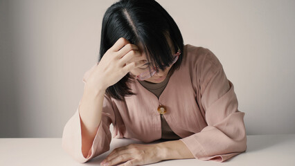 A beautiful office lady is tired from migraines while working, working too hard and stressed for work deadlines, and has office syndrome