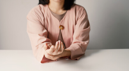 Asian business woman massaging wrist in pain Caused by working on a computer keyboard for a long time, wrist pain and numbness in the wrist. While working at the office