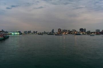 Pattaya city skyline at night with boats on the bay.
