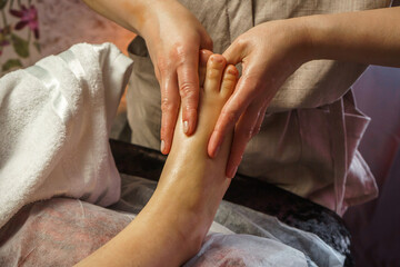 Natural medicine, reflexology, woman receiving foot massage, oppresses energy flow points, spa...