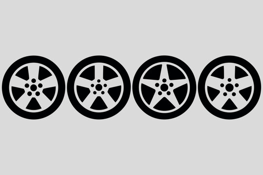 Four identical silver alloy car wheels arranged in a row