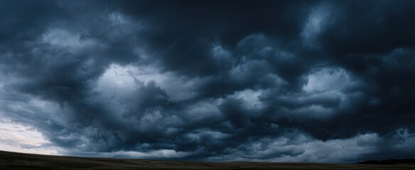 The dark storm clouds gathering over a vast landscape at twilight.